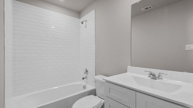 full bathroom featuring vanity, tiled shower / bath combo, and toilet