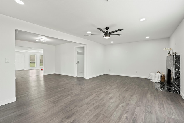 unfurnished living room featuring ceiling fan, wood-type flooring, and a premium fireplace