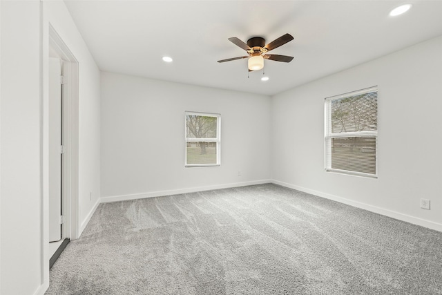 carpeted spare room featuring ceiling fan