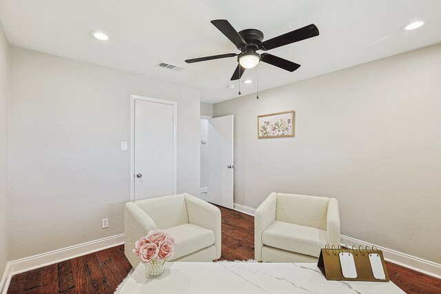 sitting room with ceiling fan and wood-type flooring