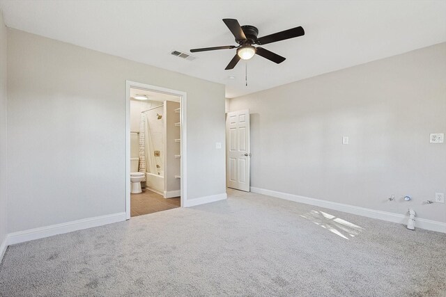 unfurnished bedroom with ceiling fan, ensuite bathroom, and light carpet