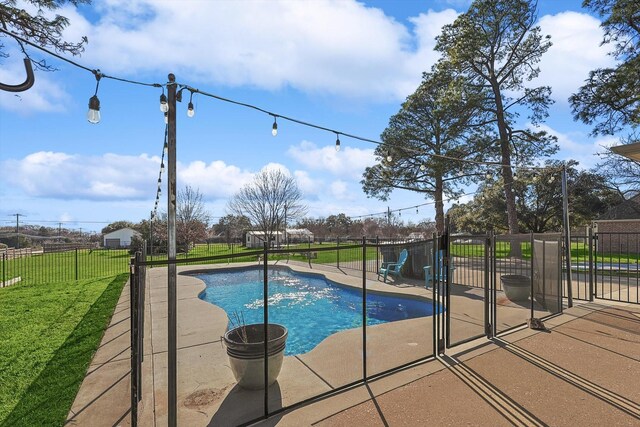 view of pool featuring a patio and a yard