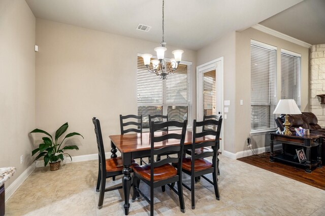 dining space with ornamental molding and an inviting chandelier