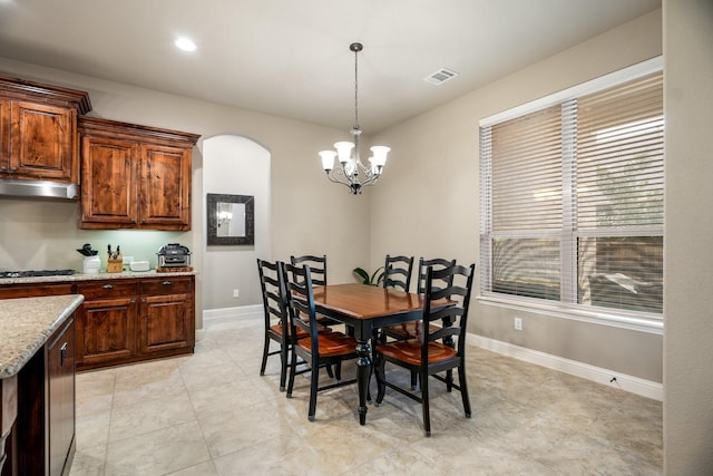 tiled dining area featuring a healthy amount of sunlight and a chandelier