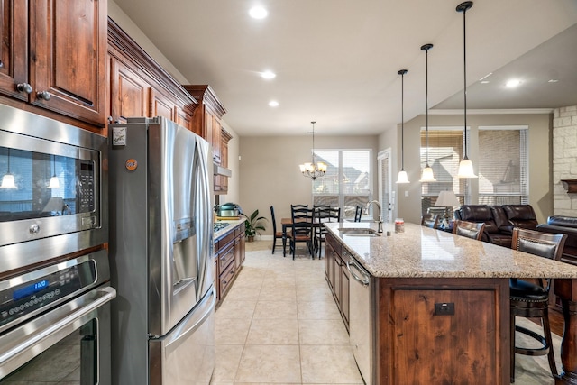 kitchen featuring sink, a notable chandelier, decorative light fixtures, a breakfast bar, and appliances with stainless steel finishes