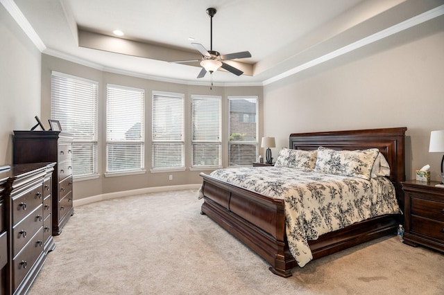 bedroom with a raised ceiling, ceiling fan, and light colored carpet