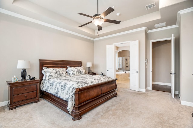 carpeted bedroom featuring a tray ceiling, ensuite bath, ceiling fan, and ornamental molding