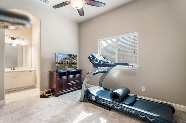 workout room with ceiling fan and light carpet