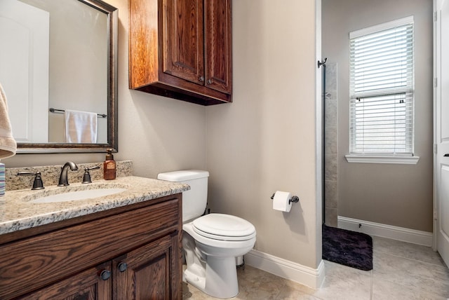 bathroom featuring tile patterned floors, plenty of natural light, toilet, and vanity