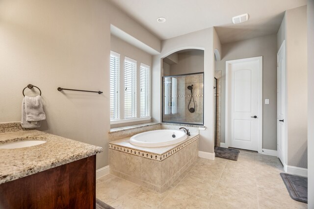 bathroom featuring tile patterned floors, vanity, and plus walk in shower