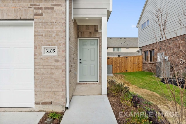 property entrance featuring a lawn and central AC unit