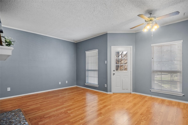 spare room featuring a textured ceiling, ceiling fan, ornamental molding, and light hardwood / wood-style flooring