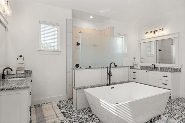 bathroom with plus walk in shower, vanity, and tile patterned flooring