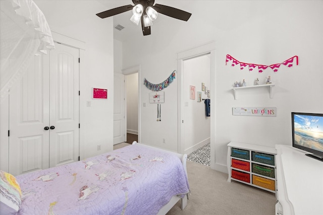 carpeted bedroom with ceiling fan and a closet