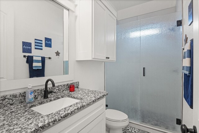 bathroom featuring an enclosed shower, vanity, and toilet