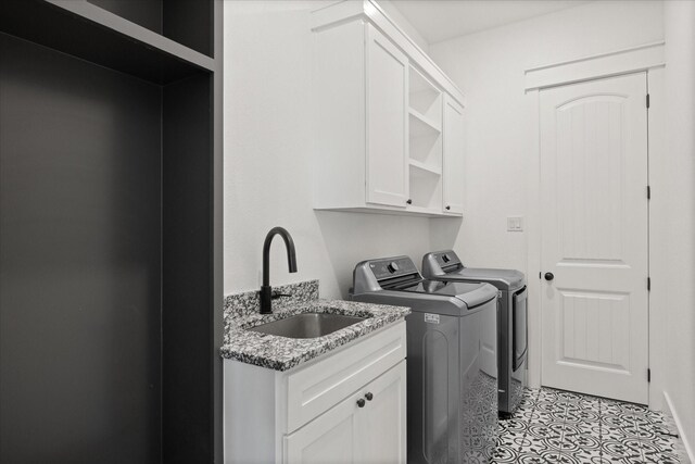 laundry room with washer and dryer, cabinets, and sink