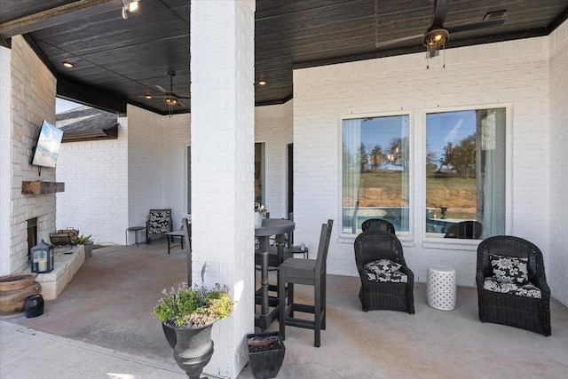 view of patio featuring an outdoor stone fireplace and ceiling fan