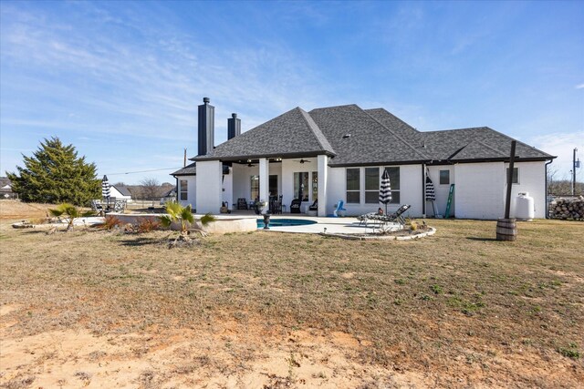 rear view of house with a patio area, ceiling fan, and a yard