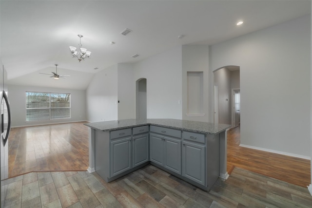 kitchen with pendant lighting, wood-type flooring, lofted ceiling, and gray cabinets