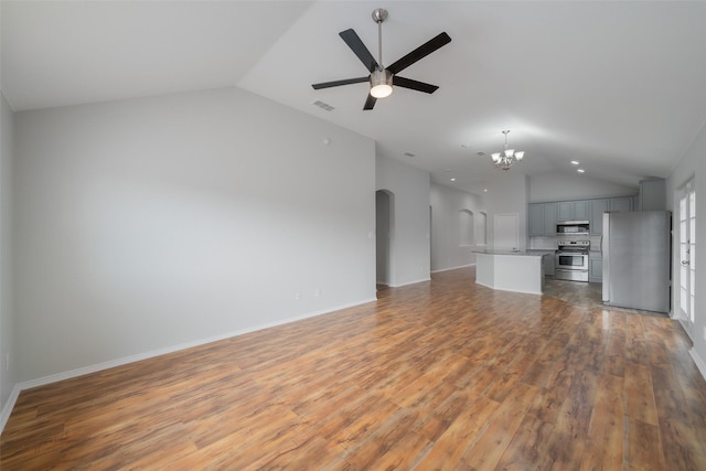 unfurnished living room featuring lofted ceiling, hardwood / wood-style floors, and ceiling fan with notable chandelier