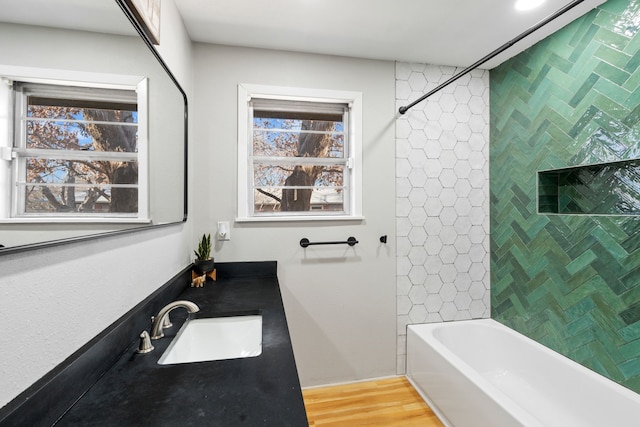 bathroom featuring vanity, tiled shower / bath combo, and hardwood / wood-style flooring