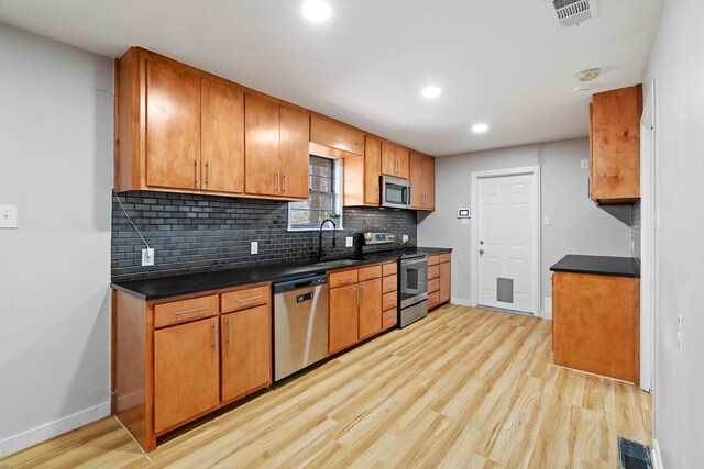 kitchen featuring appliances with stainless steel finishes, light hardwood / wood-style flooring, and sink