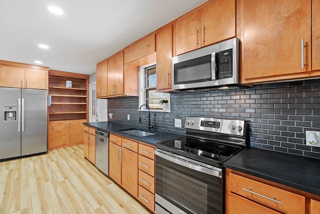 kitchen with light wood-type flooring, backsplash, stainless steel appliances, and sink