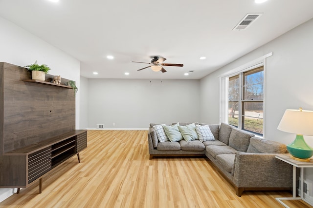 living room featuring ceiling fan and light hardwood / wood-style flooring