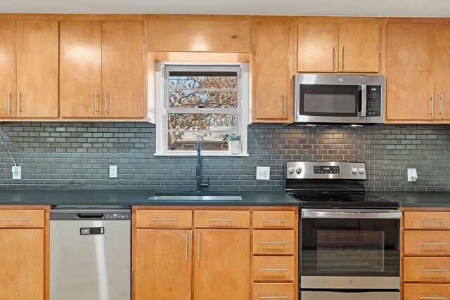 kitchen with decorative backsplash, sink, and stainless steel appliances