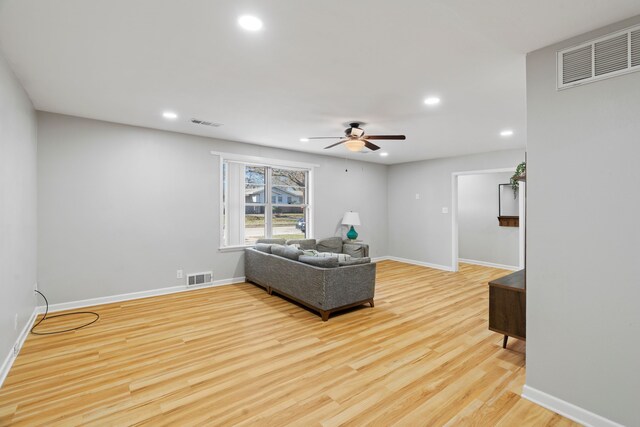 living room featuring ceiling fan and light hardwood / wood-style flooring