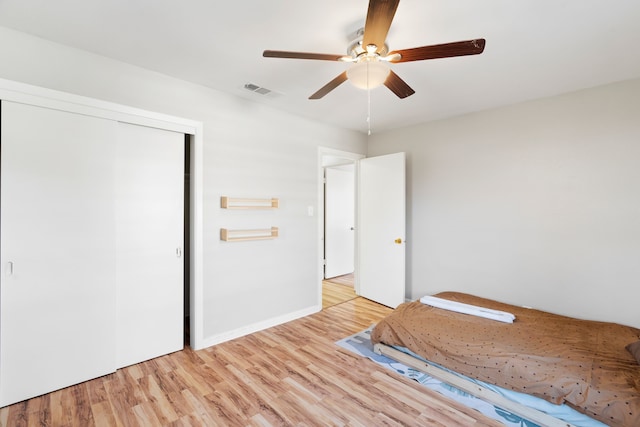 unfurnished bedroom with ceiling fan, a closet, and light hardwood / wood-style flooring