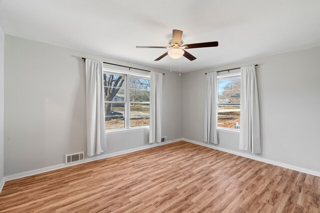 spare room featuring ceiling fan, plenty of natural light, and light wood-type flooring