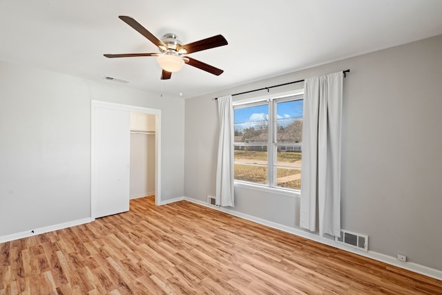 unfurnished bedroom with a closet, light hardwood / wood-style flooring, and ceiling fan