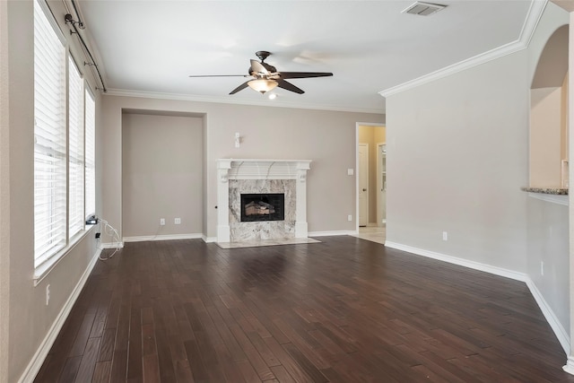 unfurnished living room featuring ceiling fan, crown molding, a fireplace, and dark wood-type flooring