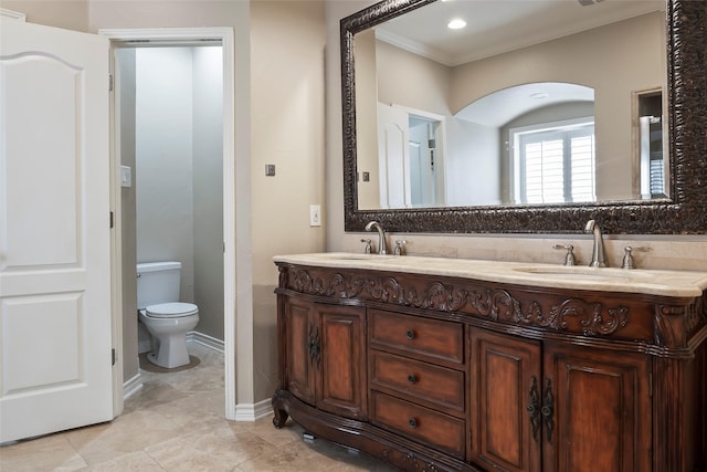 bathroom with vanity, toilet, and ornamental molding