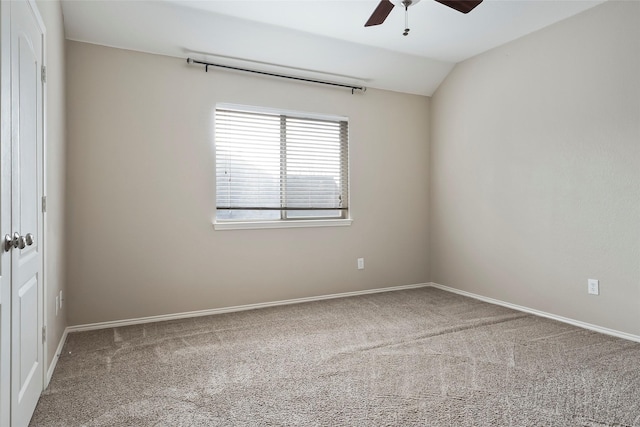 carpeted empty room featuring ceiling fan and vaulted ceiling