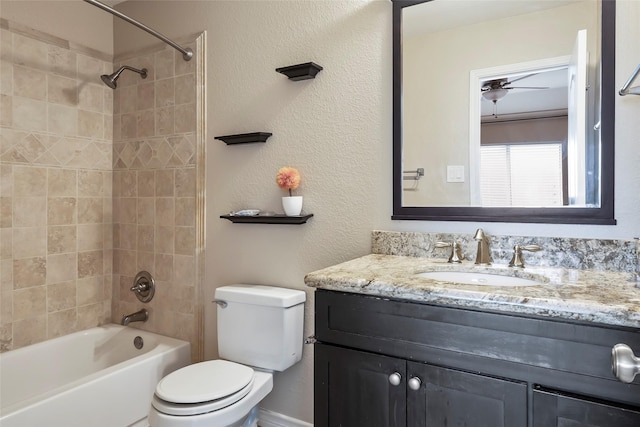 full bathroom featuring vanity, ceiling fan, tiled shower / bath, and toilet