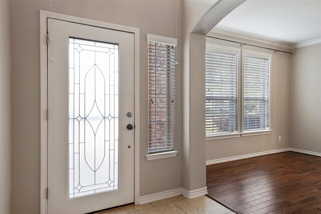 foyer featuring tile patterned flooring and crown molding