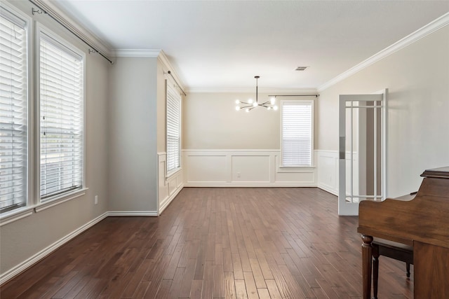 unfurnished dining area featuring an inviting chandelier, a wealth of natural light, and crown molding