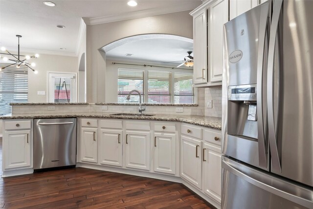 kitchen with ceiling fan with notable chandelier, sink, light stone counters, white cabinetry, and stainless steel appliances