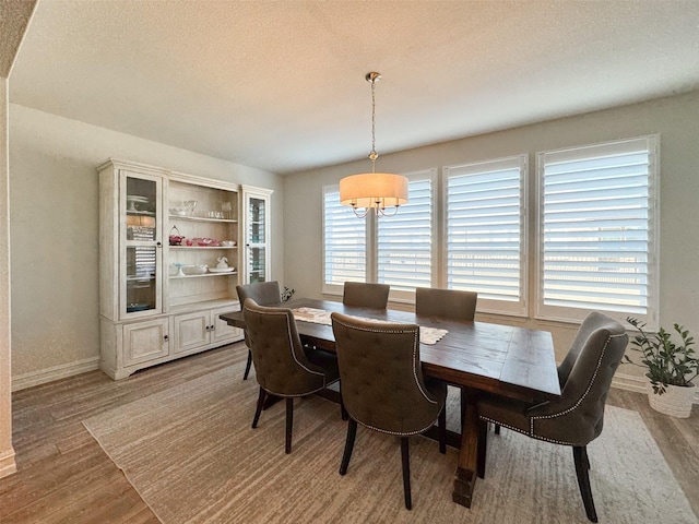 dining space with a textured ceiling and light wood-type flooring