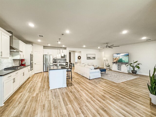 1133 Cornerstone Dr, Little Elm, TX 76227 - kitchen featuring stainless steel appliances, open floor plan, dark countertops, recessed lighting, and wall chimney exhaust hood