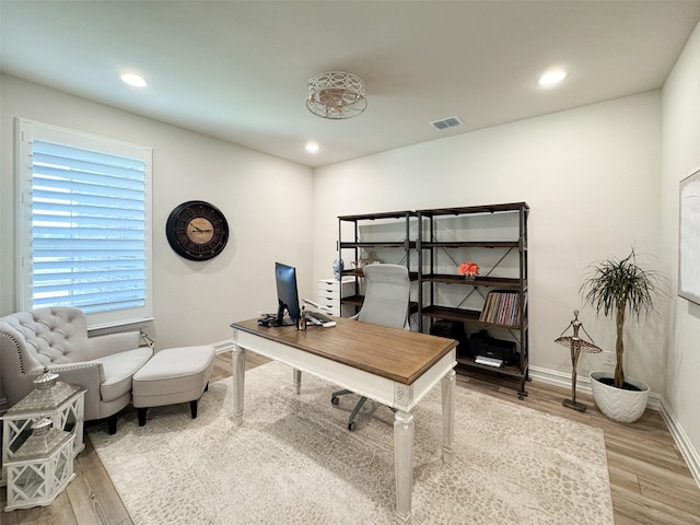 home office with light hardwood / wood-style floors