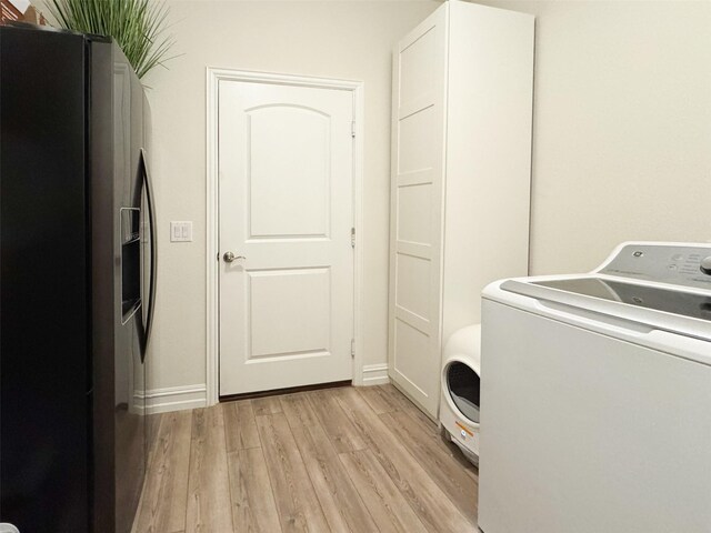 washroom featuring cabinets, washer / dryer, and light hardwood / wood-style flooring