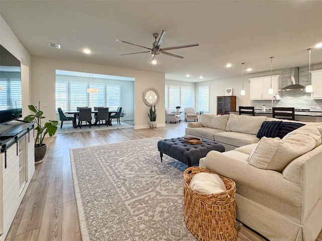 living room with ceiling fan and light hardwood / wood-style flooring