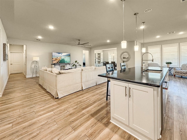 1133 Cornerstone Dr, Little Elm, TX 76227 - kitchen with a sink, open floor plan, dark countertops, a ceiling fan, and light wood-style floors