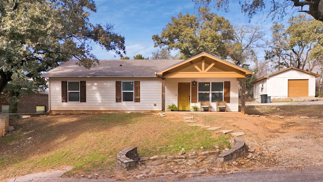 view of front of home featuring a porch, a garage, and an outbuilding