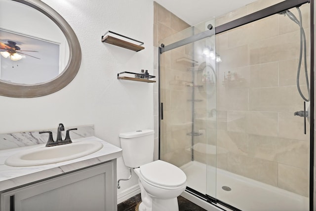 bathroom featuring ceiling fan, toilet, vanity, and walk in shower