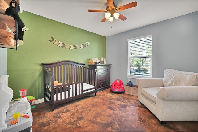 carpeted bedroom featuring a nursery area and ceiling fan