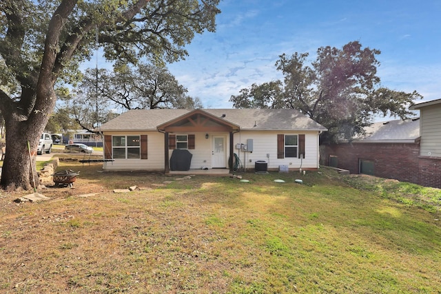 rear view of property featuring a lawn and central AC